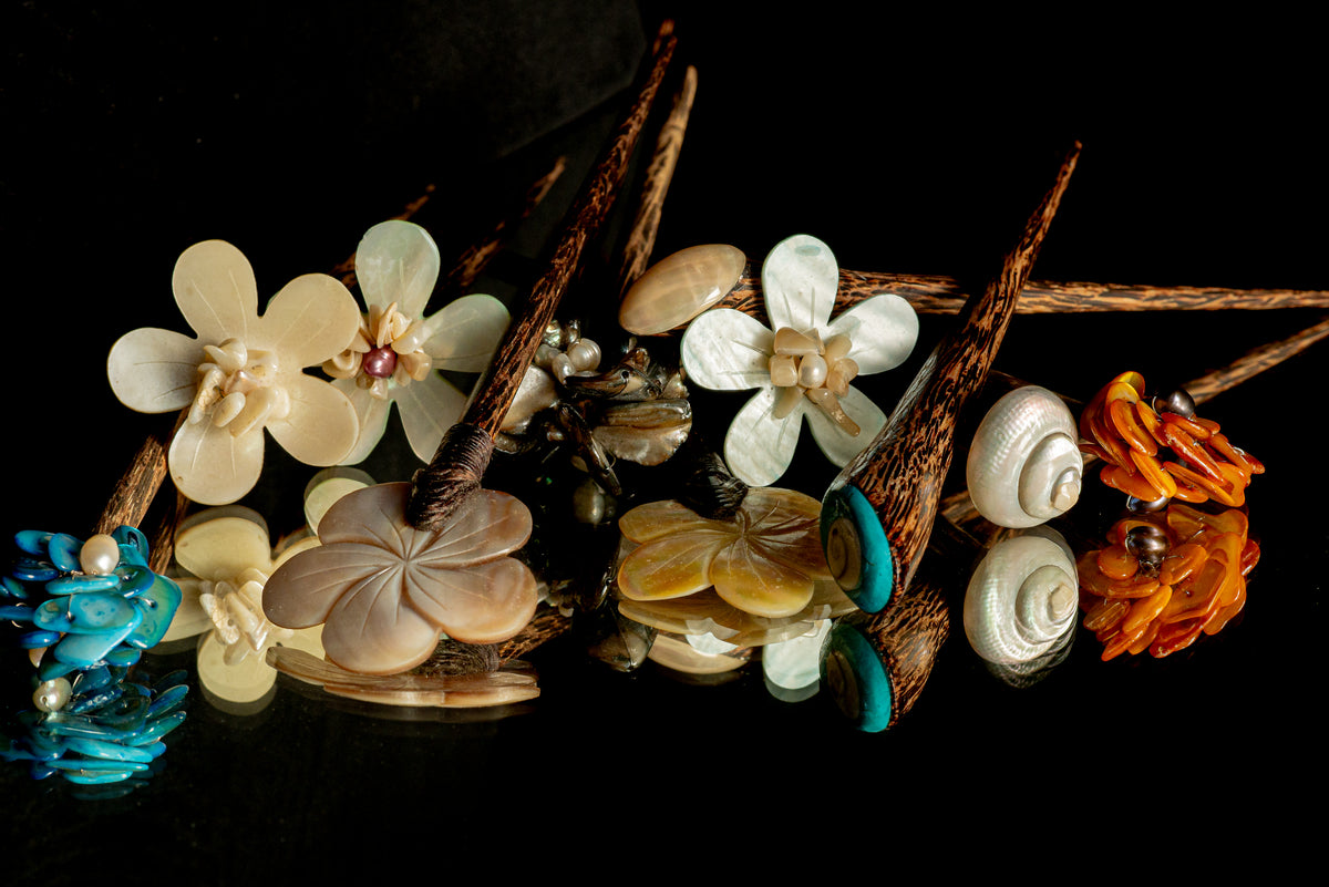 Close-up of handcrafted natural hair accessory with wood and shell elements